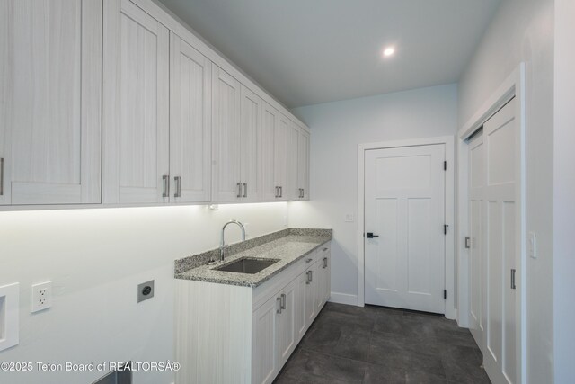 laundry area featuring sink, cabinets, and hookup for an electric dryer