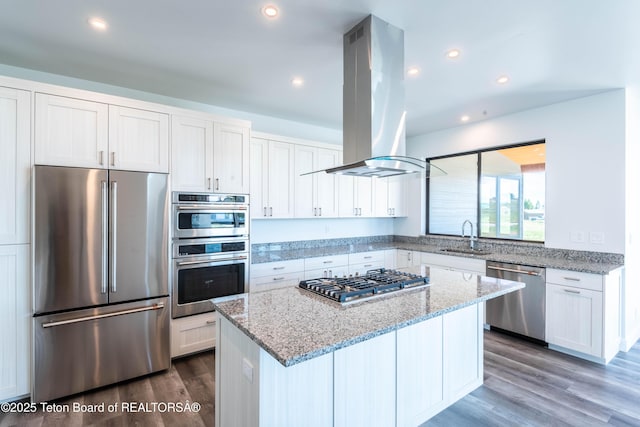 kitchen featuring sink, appliances with stainless steel finishes, a center island, white cabinets, and island exhaust hood