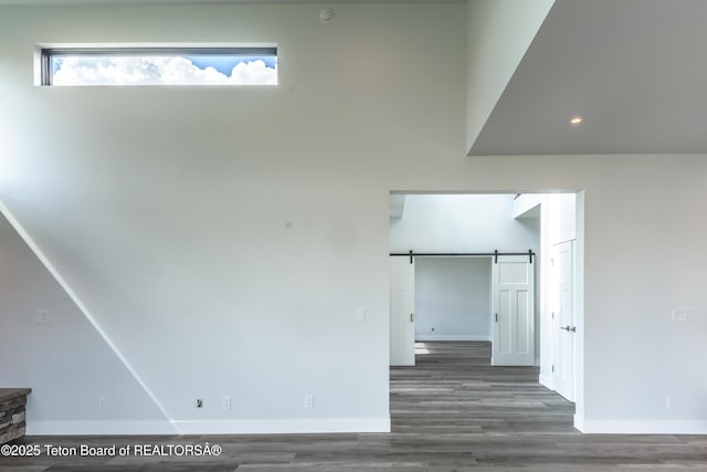 interior space with dark hardwood / wood-style floors and a barn door