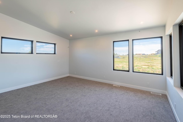 carpeted spare room with vaulted ceiling