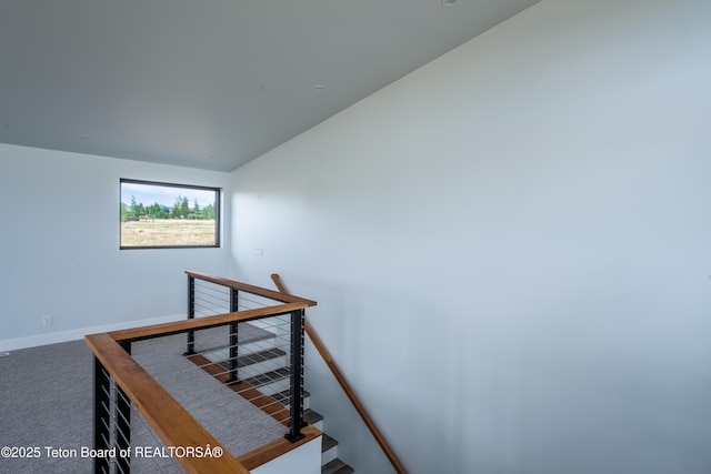 staircase with vaulted ceiling and carpet