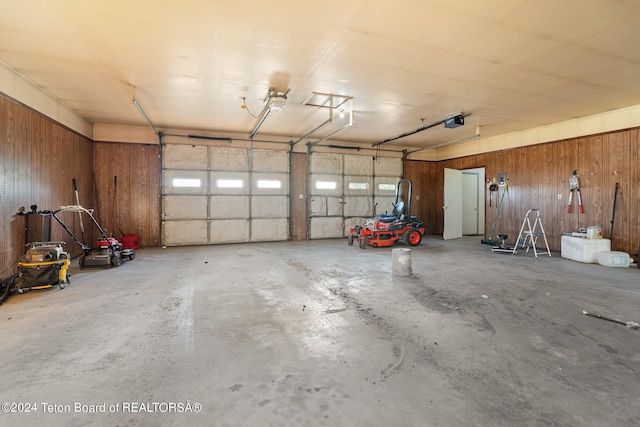 garage with a garage door opener and wooden walls