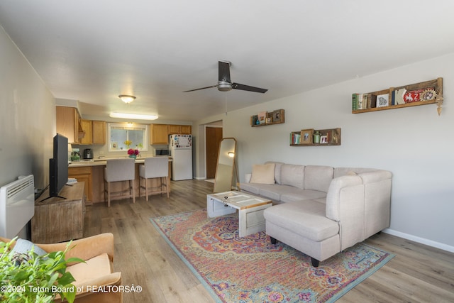 living room featuring light wood-type flooring and ceiling fan