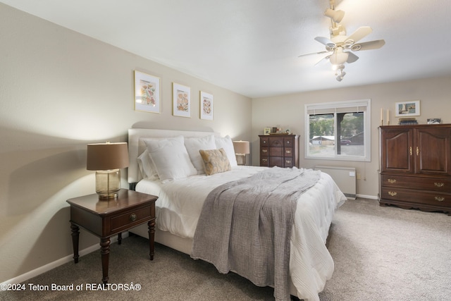 carpeted bedroom featuring ceiling fan and radiator