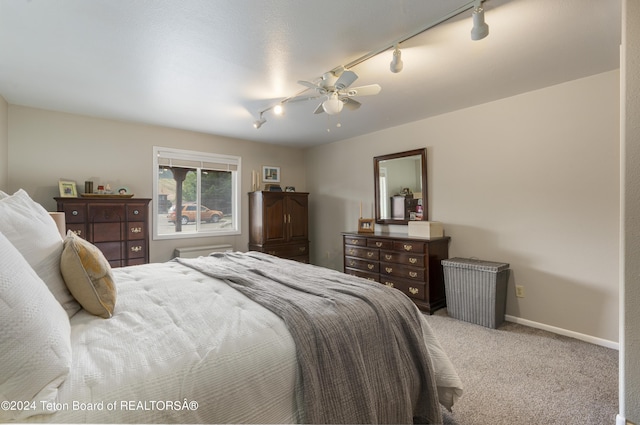 bedroom featuring light colored carpet, track lighting, and ceiling fan