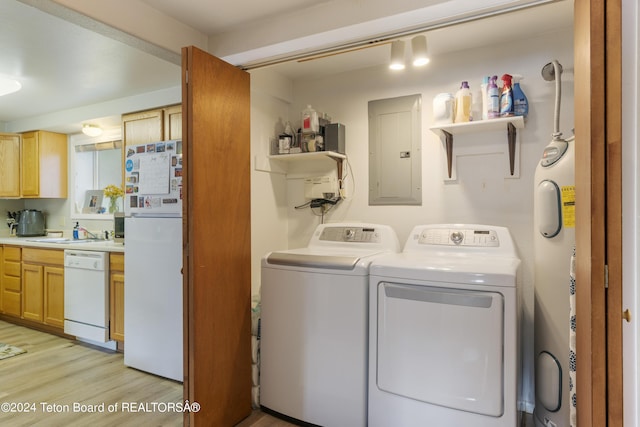 washroom with washing machine and dryer, light wood-type flooring, sink, and electric panel