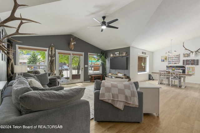 living room featuring a healthy amount of sunlight, ceiling fan, light hardwood / wood-style floors, and vaulted ceiling