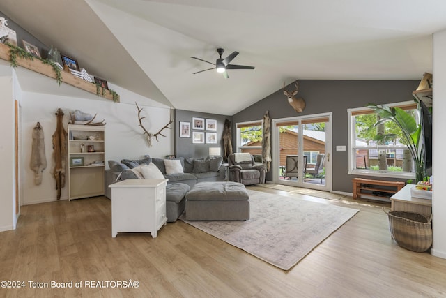 living room featuring ceiling fan, light hardwood / wood-style floors, and lofted ceiling