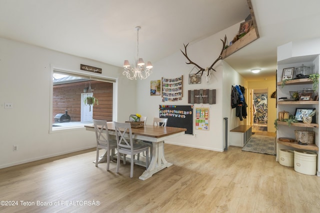 dining room with light hardwood / wood-style flooring and an inviting chandelier