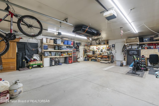 garage with a workshop area and a garage door opener