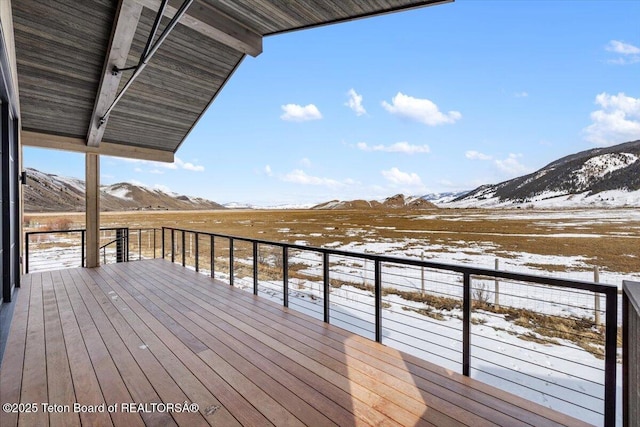 snow covered deck with a mountain view