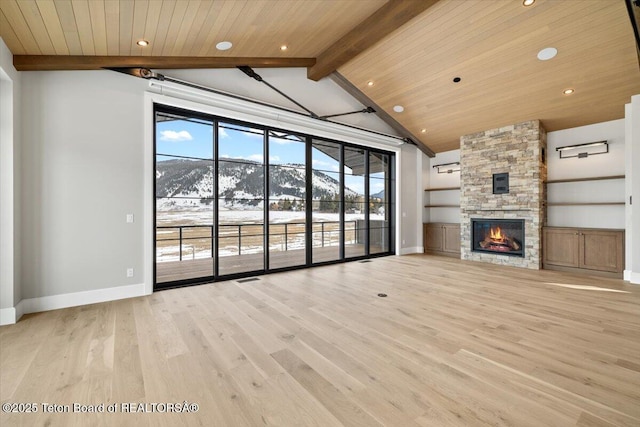 unfurnished living room featuring light wood-style floors, wooden ceiling, a fireplace, and lofted ceiling with beams