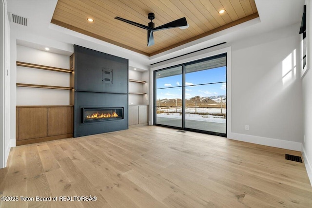 unfurnished living room with wooden ceiling, visible vents, a raised ceiling, and built in features