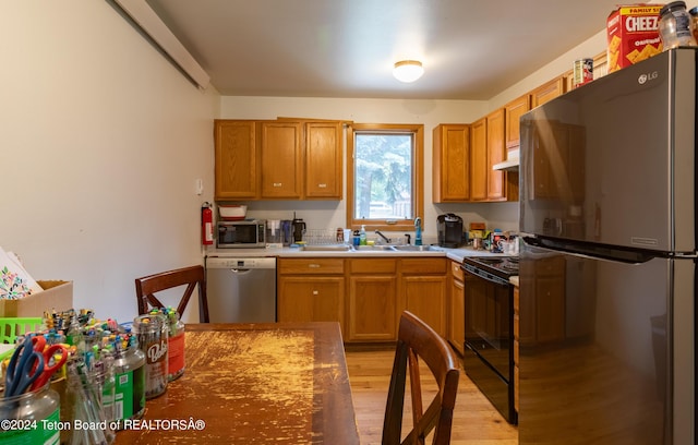 kitchen with sink, stainless steel appliances, and light hardwood / wood-style floors