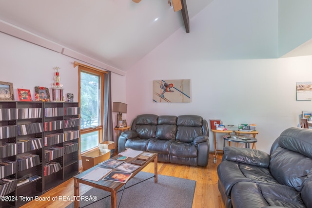 living room with plenty of natural light, lofted ceiling with beams, and light wood-type flooring