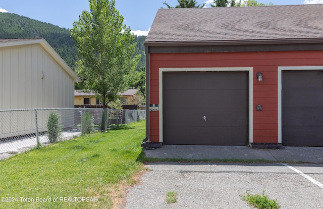 garage featuring a mountain view and a yard