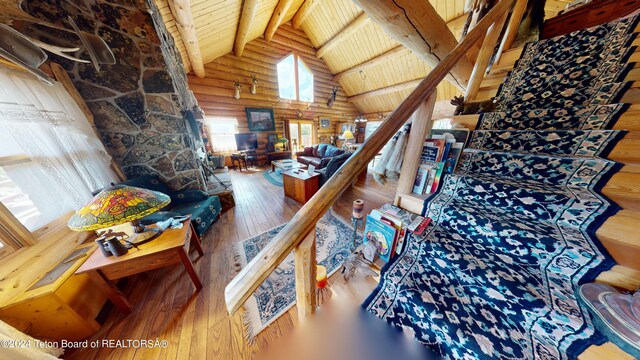 1404 Warm Springs Dr, Dubois, WY 82513 - living area with wooden ceiling with exposed beams, rustic walls, high vaulted ceiling, and hardwood / wood-style floors