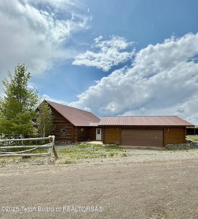 1404 Warm Springs Dr, Dubois, WY 82513 - view of side of property featuring a garage, log exterior, and metal roof