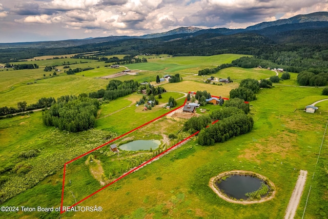 aerial view with a water and mountain view and a rural view