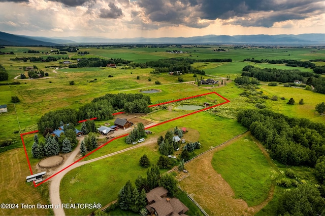 aerial view at dusk with a mountain view and a rural view