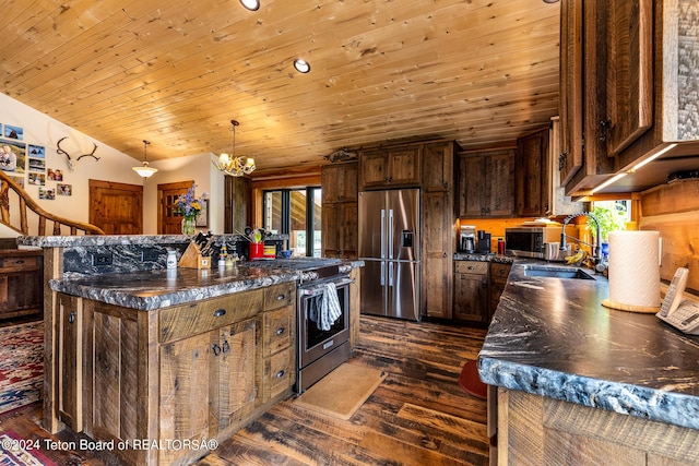 kitchen featuring dark wood-type flooring, a center island, vaulted ceiling, appliances with stainless steel finishes, and pendant lighting