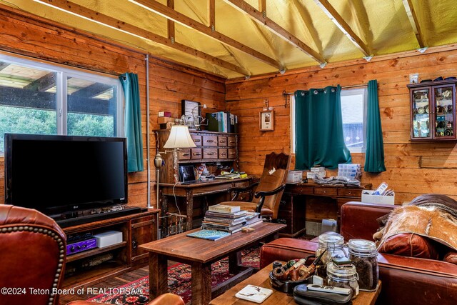 living room featuring wooden walls, lofted ceiling with beams, and wood-type flooring
