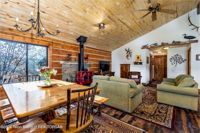 living room featuring dark wood-type flooring, vaulted ceiling, a wood stove, and wooden ceiling