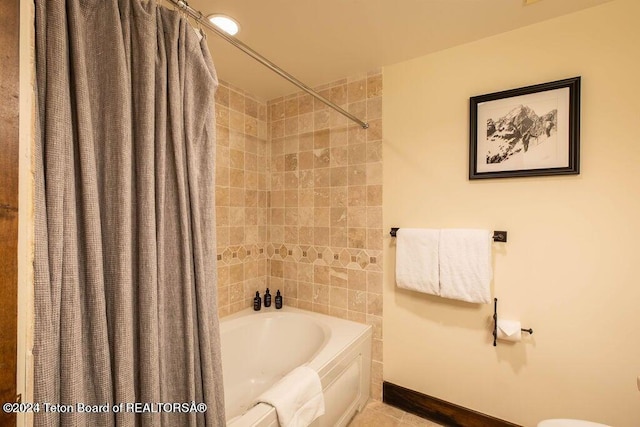 full bath featuring shower / bath combo, tile patterned floors, and baseboards