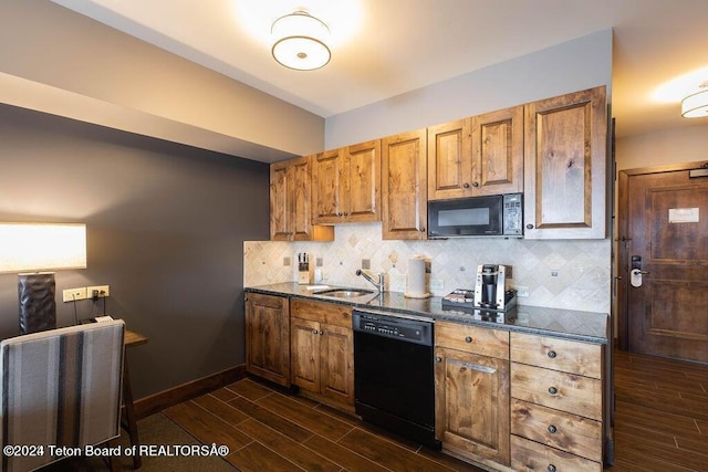 kitchen featuring a sink, backsplash, wood tiled floor, dark stone counters, and black appliances