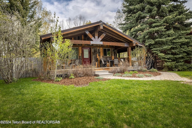 1655 E J-W Dr, Jackson, WY 83001 - view of front facade featuring a front yard, fence, and covered porch