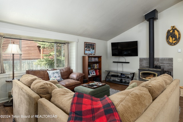 living room with a wood stove, lofted ceiling, and dark wood-type flooring