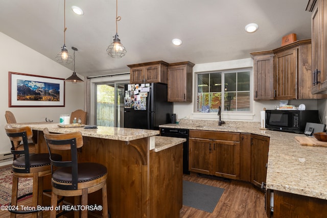 kitchen featuring black appliances, hanging light fixtures, a kitchen breakfast bar, vaulted ceiling, and sink