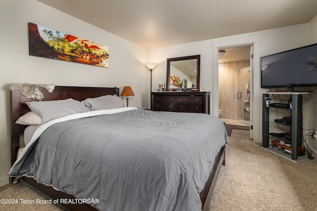 carpeted bedroom featuring ensuite bath