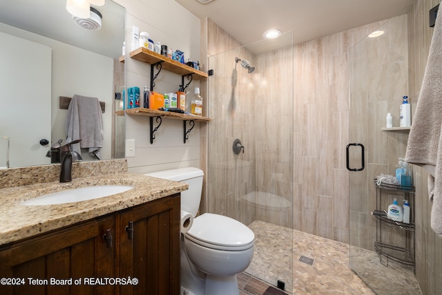 bathroom with toilet, vanity, and an enclosed shower