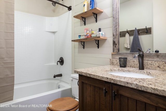 full bathroom featuring vanity, tiled shower / bath, and toilet