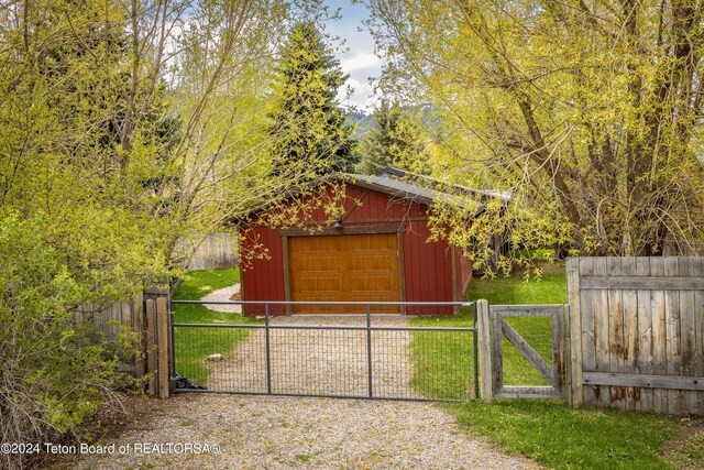 1655 E J-W Dr, Jackson, WY 83001 - view of outdoor structure featuring an outdoor structure, fence, a gate, and driveway