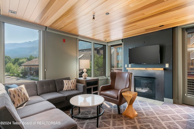 living room with a mountain view, a wall of windows, and wooden ceiling