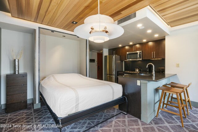 carpeted bedroom featuring sink, stainless steel refrigerator, and wooden ceiling