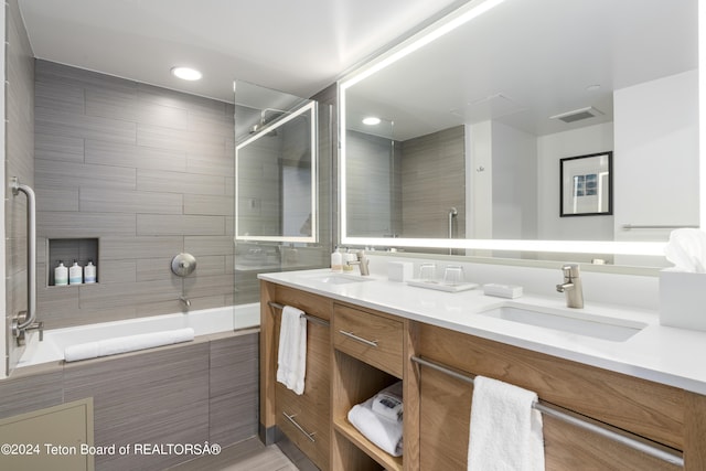 bathroom featuring tiled shower / bath combo and vanity