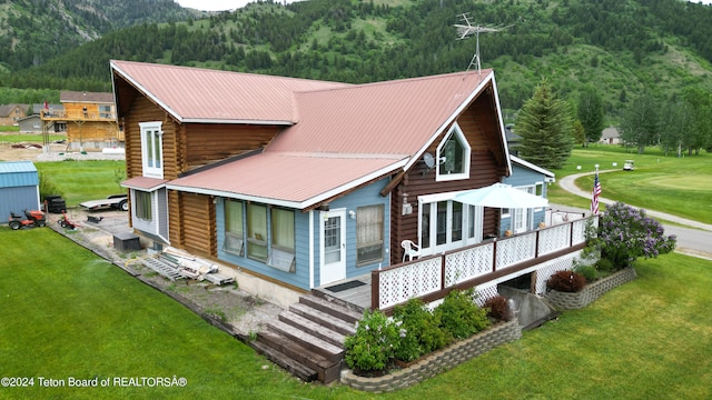 rear view of property with a deck and a yard