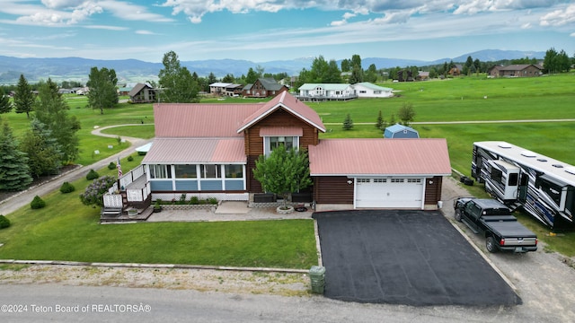 view of front of home featuring a garage, a front lawn, and a mountain view