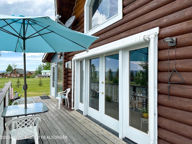 wooden terrace featuring french doors and a yard