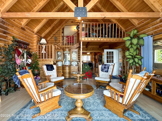 living room with beamed ceiling, rustic walls, high vaulted ceiling, wooden ceiling, and hardwood / wood-style flooring