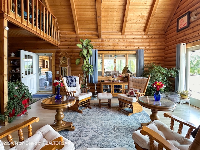 living room with wooden ceiling, high vaulted ceiling, a healthy amount of sunlight, and rustic walls