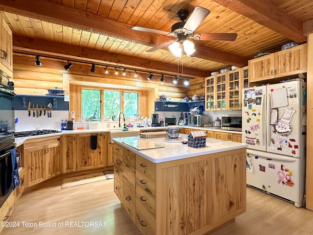 kitchen featuring light hardwood / wood-style flooring, beam ceiling, log walls, and stainless steel appliances