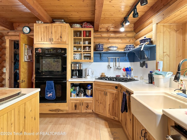 kitchen with stainless steel gas cooktop, log walls, light hardwood / wood-style floors, double oven, and track lighting