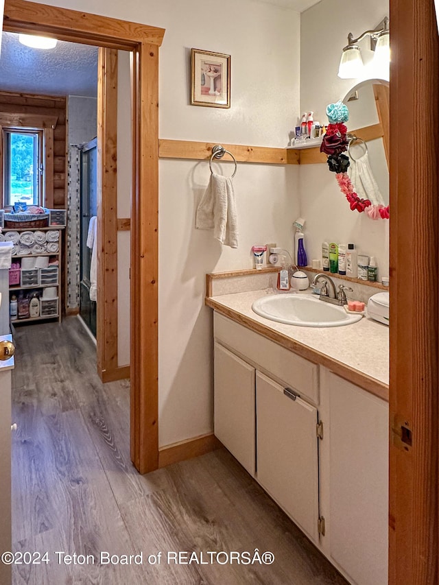 bathroom with vanity, a textured ceiling, and wood-type flooring