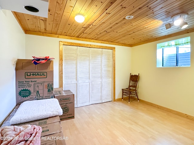 bedroom with wood ceiling, light wood-type flooring, and a closet