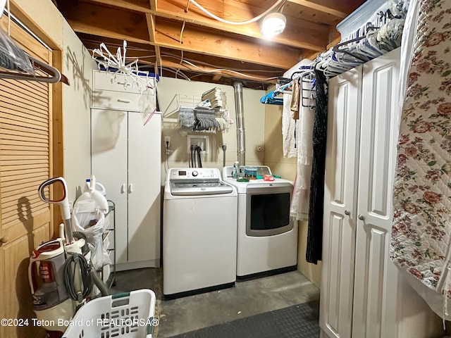 washroom featuring cabinets and washer and clothes dryer