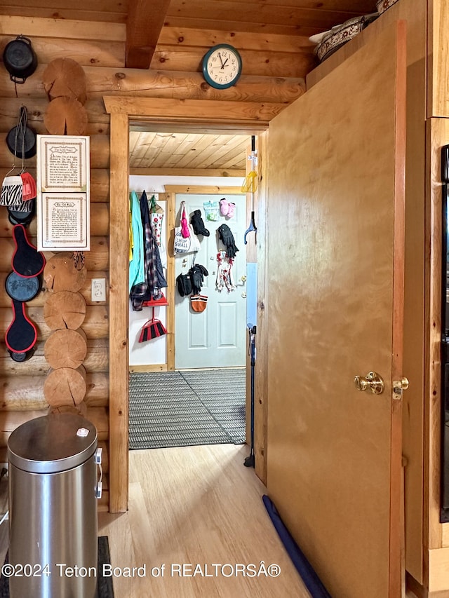 hall featuring wooden ceiling, wood-type flooring, and rustic walls